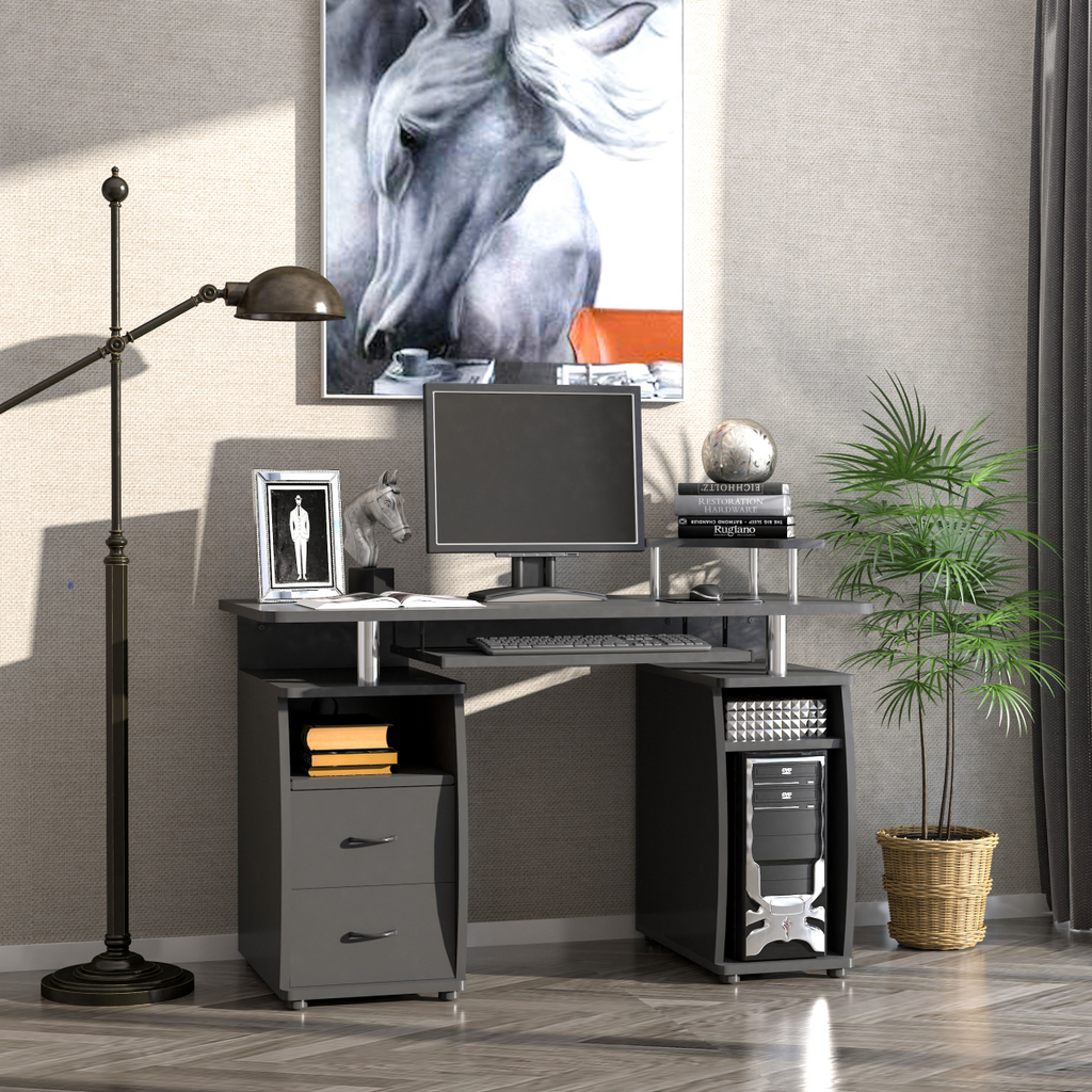 Black HomeCraft computer office desk featuring a keyboard tray, drawer, and monitor shelf in a modern workspace setting.