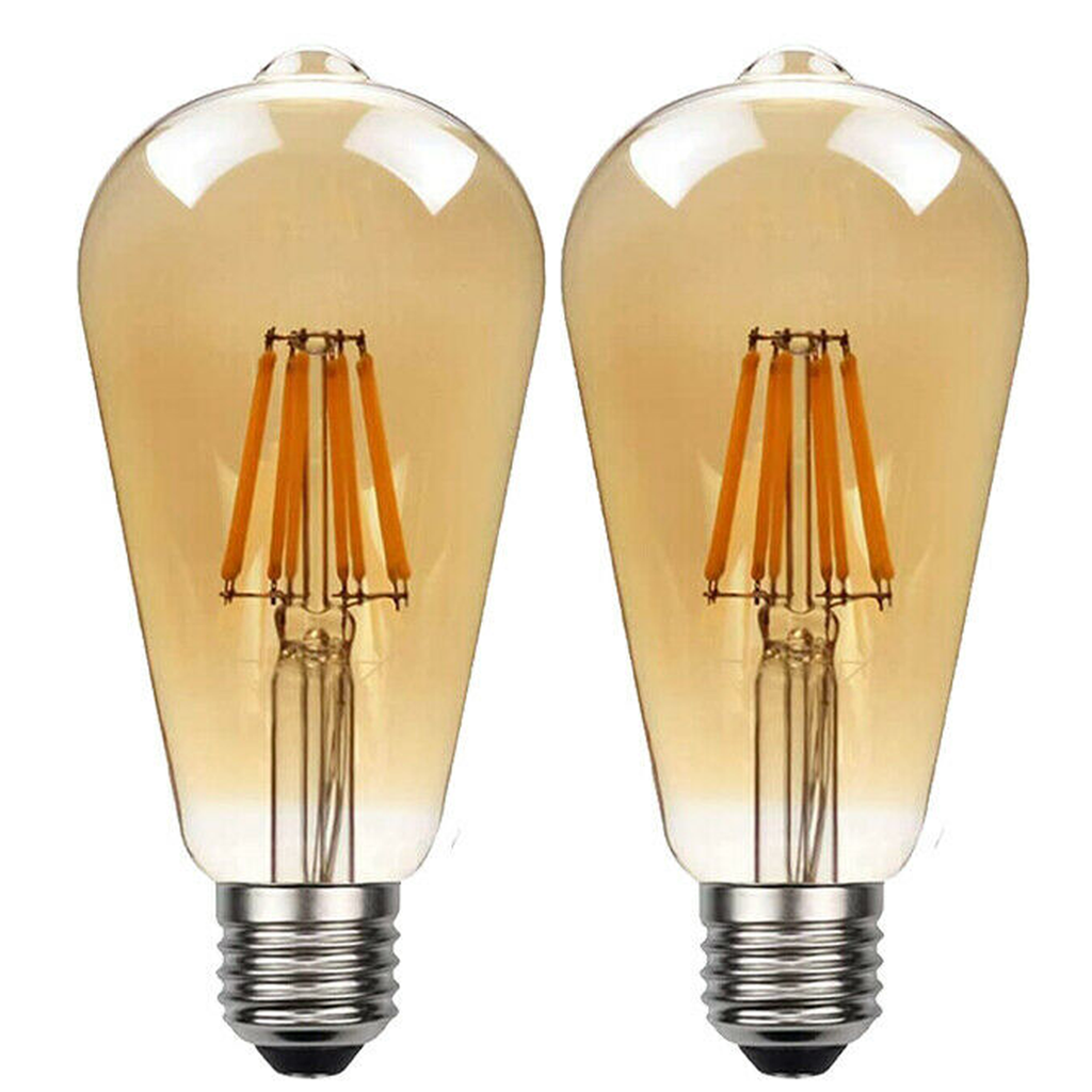 Two Ledsone vintage amber ST64 LED Edison bulbs, E27 dimmable, glowing softly at 2700K in a warm home setting.