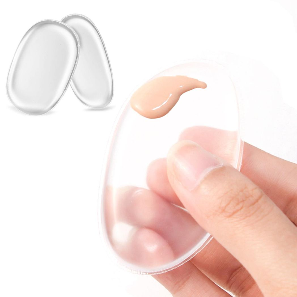 Clear silicone make-up sponge by GlowCare resting on a clean surface, showcasing its smooth texture and ergonomic design.