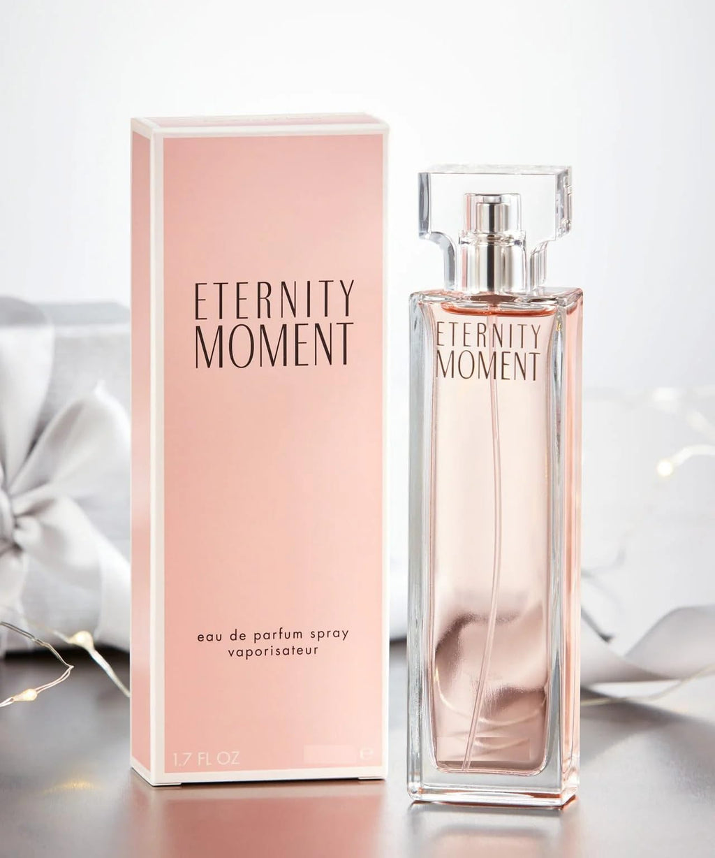 Calvin Klein Eternity Moment Eau De Parfum Spray 50ml in a sleek bottle with floral design on a soft background.