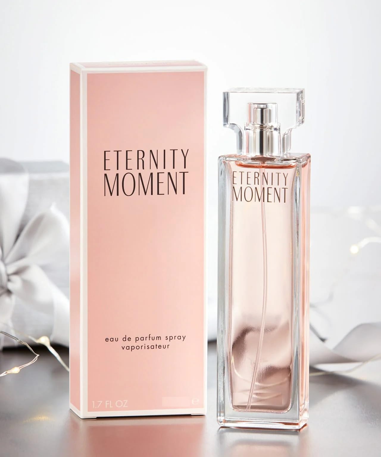 Calvin Klein Eternity Moment Eau De Parfum Spray 50ml in a sleek bottle with floral design on a soft background.