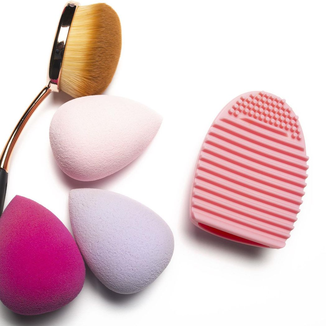 Silicone egg sponge scrubber in pink and purple for cleaning makeup brushes by GlowCare.