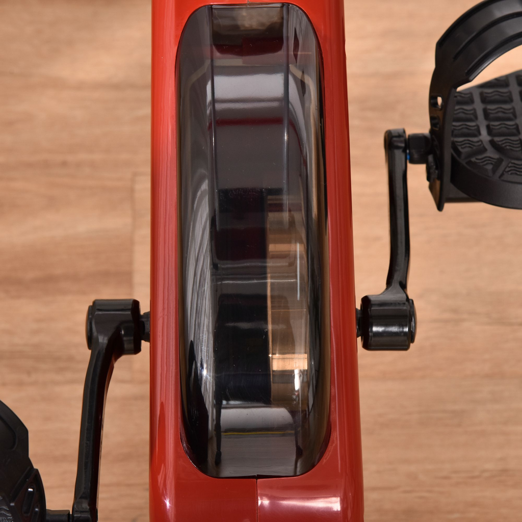 Foldable red magnetic resistance exercise bike with adjustable seat and LCD display, designed for home workouts.