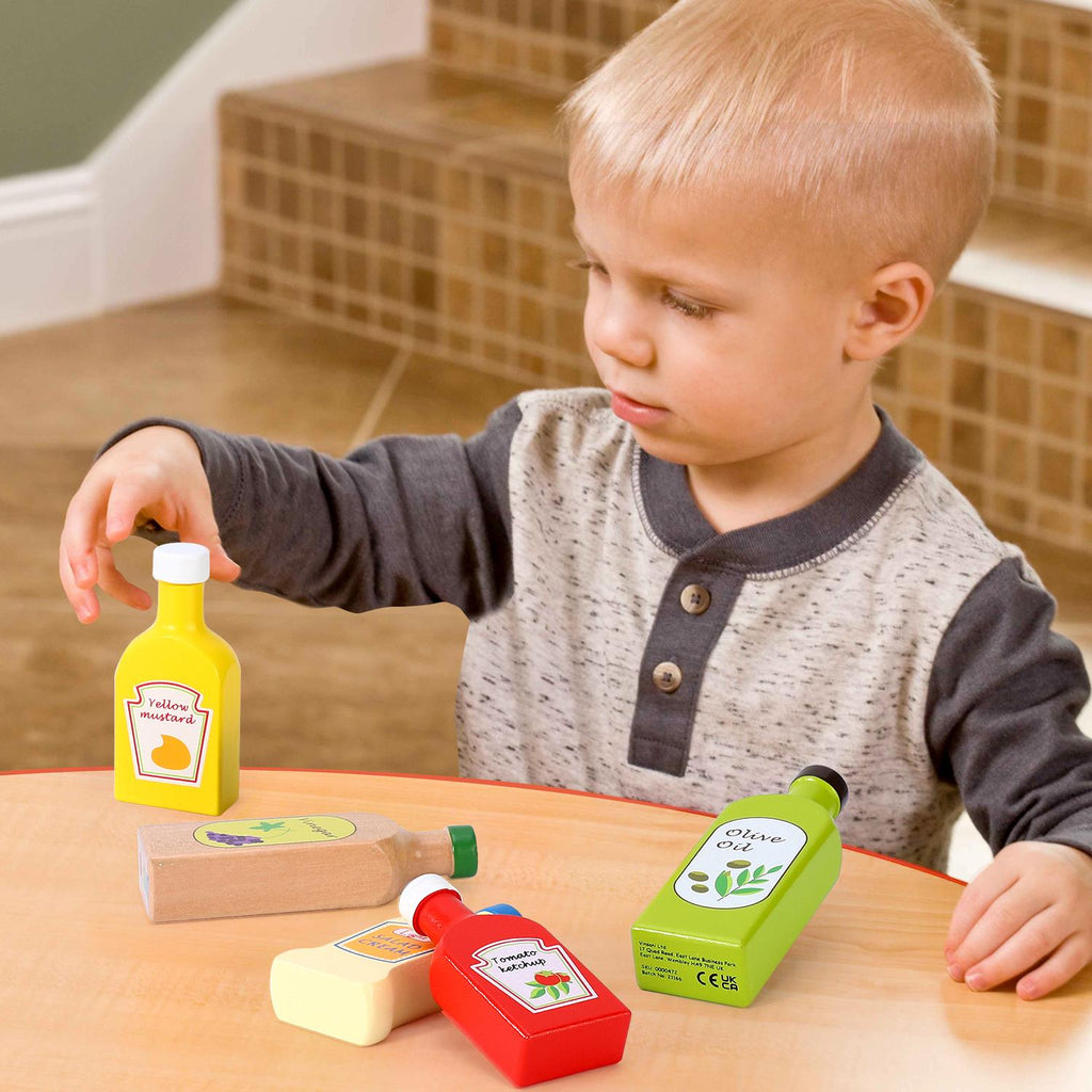 Five wooden bottles in a Sauces and Oils Set for educational pretend play by SOKA Play Imagine Learn.
