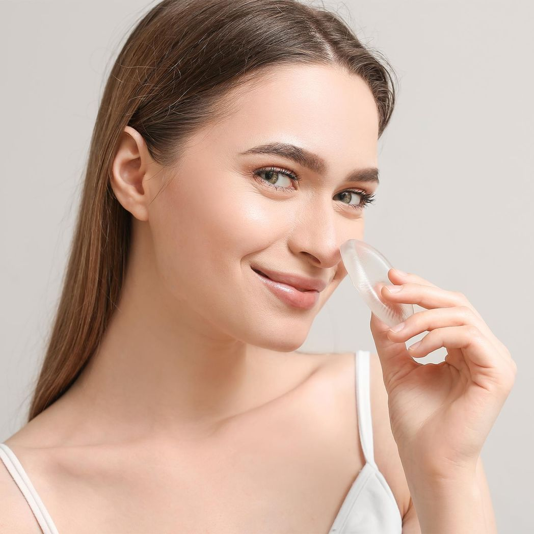 Clear silicone make-up sponge from GlowCare, showcasing its smooth surface and ergonomic design for flawless application.
