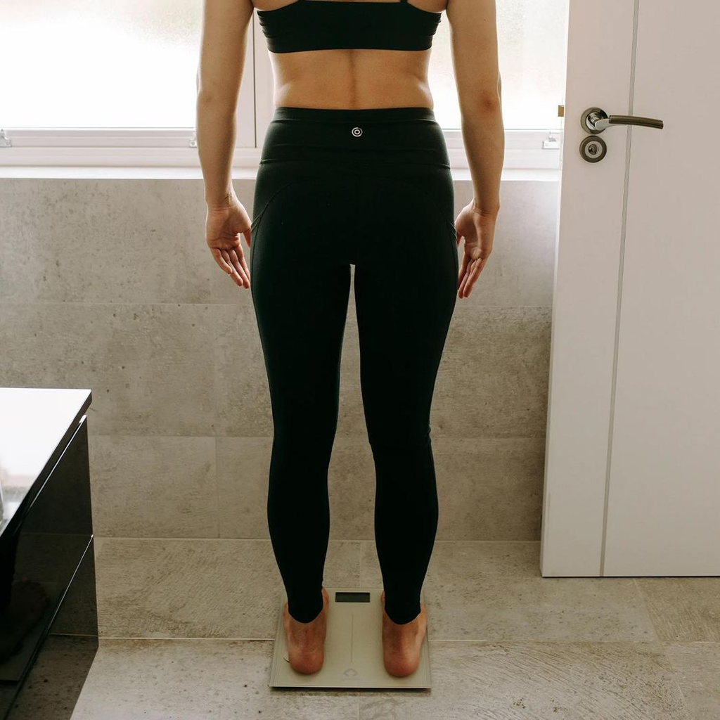 Body analysis scale in space grey by Gymcline showing BMI report and calorie intake guide on digital display.