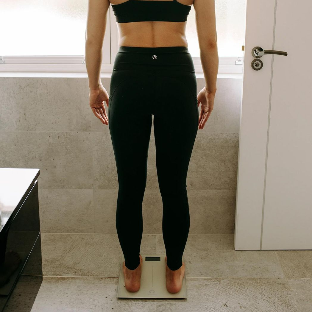 Body analysis scale in space grey by Gymcline showing BMI report and calorie intake guide on digital display.